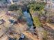 An aerial perspective showcases the home with its large private pond, surrounded by lush greenery and trees at H-5422 Hill Sw Rd, Powder Springs, GA 30127