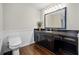 Modern bathroom with stylish vanity, dark counter top, and wood-look floors at H-5422 Hill Sw Rd, Powder Springs, GA 30127