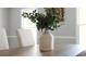 Dining room close up on dining table with stylish white vase and green vegetation at H-5422 Hill Sw Rd, Powder Springs, GA 30127
