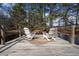 Two white Adirondack chairs sit on a wooden dock, offering a tranquil spot for relaxation by the water at H-5422 Hill Sw Rd, Powder Springs, GA 30127