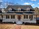 Beautiful home featuring a covered porch, black shutters, red door, and a brick walkway at H-5422 Hill Sw Rd, Powder Springs, GA 30127