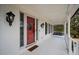 Spacious porch with a red door, white columns, and a cozy porch swing at H-5422 Hill Sw Rd, Powder Springs, GA 30127
