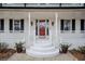 Inviting front porch with red door, stylish sconces, and brick steps at H-5422 Hill Sw Rd, Powder Springs, GA 30127