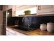 Modern kitchen featuring butcher block countertops and a black tile backsplash with gold hardware at H-5422 Hill Sw Rd, Powder Springs, GA 30127