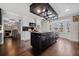 Open concept kitchen with dark wood flooring and an island with black cabinets and granite countertops at H-5422 Hill Sw Rd, Powder Springs, GA 30127