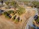 Aerial view of a large grassy lot bordered by mature trees, a white fence, and a curved road at H-5422 Hill Sw Rd, Powder Springs, GA 30127
