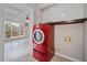 Laundry area with a red washer/dryer unit and open access to a bright sunroom at H-5422 Hill Sw Rd, Powder Springs, GA 30127
