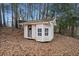 A cute backyard shed with windows and a door, perfect for storage or a hobby space at H-5422 Hill Sw Rd, Powder Springs, GA 30127