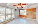 Bright sunroom featuring a ceiling fan, tile floors, large windows, and a unique wine-themed accent wall at H-5422 Hill Sw Rd, Powder Springs, GA 30127