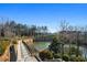 Beautiful waterfront view with lush landscaping, a paved walkway, and mature trees at 6669 Encore Blvd, Atlanta, GA 30328