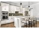 Modern kitchen with stainless steel appliances, white cabinets and an island with seating at 6669 Encore Blvd, Atlanta, GA 30328