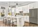 Charming kitchen features white cabinets, island with seating, pendant lights, and stainless steel refrigerator at 6669 Encore Blvd, Atlanta, GA 30328