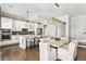 Open-concept kitchen and dining area, featuring white cabinetry, a large island, and elegant lighting at 6669 Encore Blvd, Atlanta, GA 30328