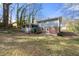 View of the backyard with a screened porch and brick foundation, surrounded by mature trees at 772 Verde Dr, Riverdale, GA 30274