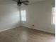 Bright bedroom featuring light-colored walls, wood-look flooring, a ceiling fan, and natural light from two windows at 5611 Executive Way, Norcross, GA 30071