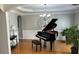 Elegant living room with grand piano, chandelier, and hardwood floors at 4107 Suwanee Trail Way, Buford, GA 30518