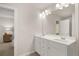 Bright bathroom with a double sink vanity, large mirror, and view into bedroom at 9458 Cedar Grove Ct # 330, Jonesboro, GA 30238