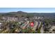 A high-angle drone shot captures a neighborhood with tree-lined streets, lush greenery, and mountain views at 203 Roseman Way, Woodstock, GA 30188