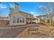 Backyard view featuring a covered patio, well-maintained lawn, and surrounding trees at 203 Roseman Way, Woodstock, GA 30188