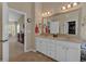 Well-lit bathroom featuring a double sink vanity with a large mirror and updated fixtures at 203 Roseman Way, Woodstock, GA 30188