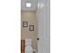 Small powder room with a white toilet, wooden cabinet, neutral paint, and minimal wall decor at 203 Roseman Way, Woodstock, GA 30188