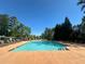 Community swimming pool with ample lounge chairs, perfect for relaxation and summer fun at 203 Roseman Way, Woodstock, GA 30188