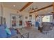 Covered patio with stone flooring, outdoor furniture, grill, ceiling fan, and wood beams at 203 Roseman Way, Woodstock, GA 30188