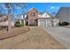 Attractive two-story home with brick and siding, set on a well-maintained lawn and driveway at 203 Roseman Way, Woodstock, GA 30188
