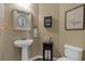 Cozy half bathroom features stylish mirror, pedestal sink, and charming decorative touches at 203 Roseman Way, Woodstock, GA 30188
