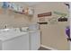 Efficient laundry room with washer, dryer, shelving and whimsical decor at 203 Roseman Way, Woodstock, GA 30188