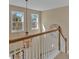 Stylish staircase with white railings and natural light filtering through the windows above at 203 Roseman Way, Woodstock, GA 30188