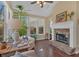 Bright sun room showcases a fireplace, natural light from large windows, and hardwood flooring at 203 Roseman Way, Woodstock, GA 30188