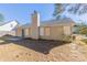 Backyard with a concrete patio, beige siding, a chimney, and a large grassy area at 5193 Seaside Ct, Atlanta, GA 30349