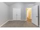 Neutral bedroom features vaulted ceiling, light gray carpet and walls, closet, and doorways to the hallway at 5193 Seaside Ct, Atlanta, GA 30349