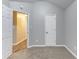 A carpeted bedroom with neutral paint, vaulted ceiling, and entry to other rooms at 5193 Seaside Ct, Atlanta, GA 30349