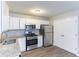 Bright kitchen with stainless steel appliances, granite countertops, and white cabinetry at 5193 Seaside Ct, Atlanta, GA 30349