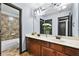 Bathroom with double sinks, a large mirror, and a tiled shower/tub combo in the background at 120 Daniel Creek Ln, Sugar Hill, GA 30518