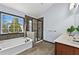 Bright bathroom with a soaking tub under a window and a separate glass-enclosed shower at 120 Daniel Creek Ln, Sugar Hill, GA 30518