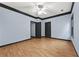 Bedroom with wood floors, large window, ceiling fan, and paneled doors at 120 Daniel Creek Ln, Sugar Hill, GA 30518