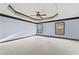 Spacious bedroom with a tray ceiling, ceiling fan, neutral carpet, and windows for natural light at 120 Daniel Creek Ln, Sugar Hill, GA 30518