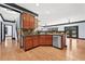 Open concept kitchen featuring wood cabinets, stainless steel dishwasher, and hardwood floors at 120 Daniel Creek Ln, Sugar Hill, GA 30518