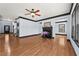 Spacious living room featuring hardwood floors, fireplace, and modern ceiling fan at 120 Daniel Creek Ln, Sugar Hill, GA 30518