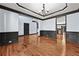 Open living room with hardwood floors, wainscoting and access to other rooms at 120 Daniel Creek Ln, Sugar Hill, GA 30518