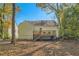 View of the backyard with a wooden deck and stairs surrounded by trees and fallen leaves at 1801 Beecher Sw St, Atlanta, GA 30310