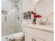 Bright bathroom with a glass-enclosed shower, neutral tile, and a round mirror above the vanity at 1801 Beecher Sw St, Atlanta, GA 30310