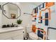 Modern bathroom with a white vanity, octagonal mirror, and shower with a patterned shower curtain at 1801 Beecher Sw St, Atlanta, GA 30310