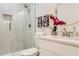 Bright bathroom featuring a glass shower, neutral tile, and a round mirror above the vanity at 1801 Beecher Sw St, Atlanta, GA 30310