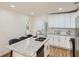 Bright kitchen featuring granite countertops, modern appliances, white cabinets, and a stacked washer/dryer at 1801 Beecher Sw St, Atlanta, GA 30310