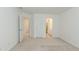 Carpeted bedroom with two doorways, white walls, and white doors adding architectural interest at 2474 Starfire Ln, Loganville, GA 30052
