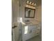 Bright bathroom featuring a white vanity with stone countertops, framed mirror and a modern light fixture at 2878 Belfaire Lake Dr, Dacula, GA 30019